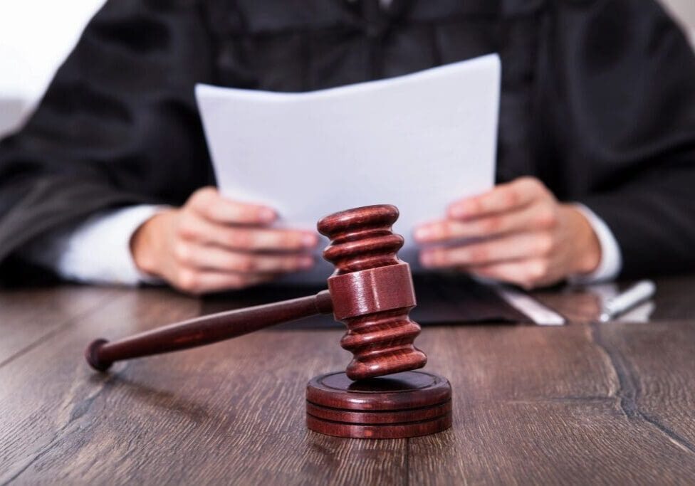 A judge 's gavel sitting on top of a wooden table.