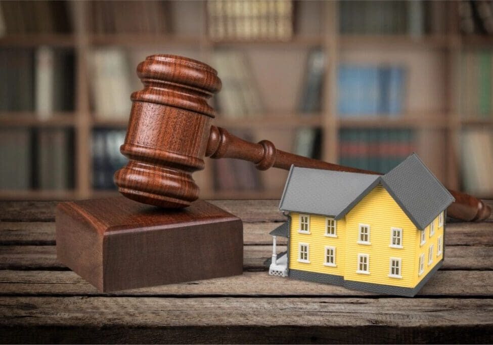 A wooden gavel next to a toy house.